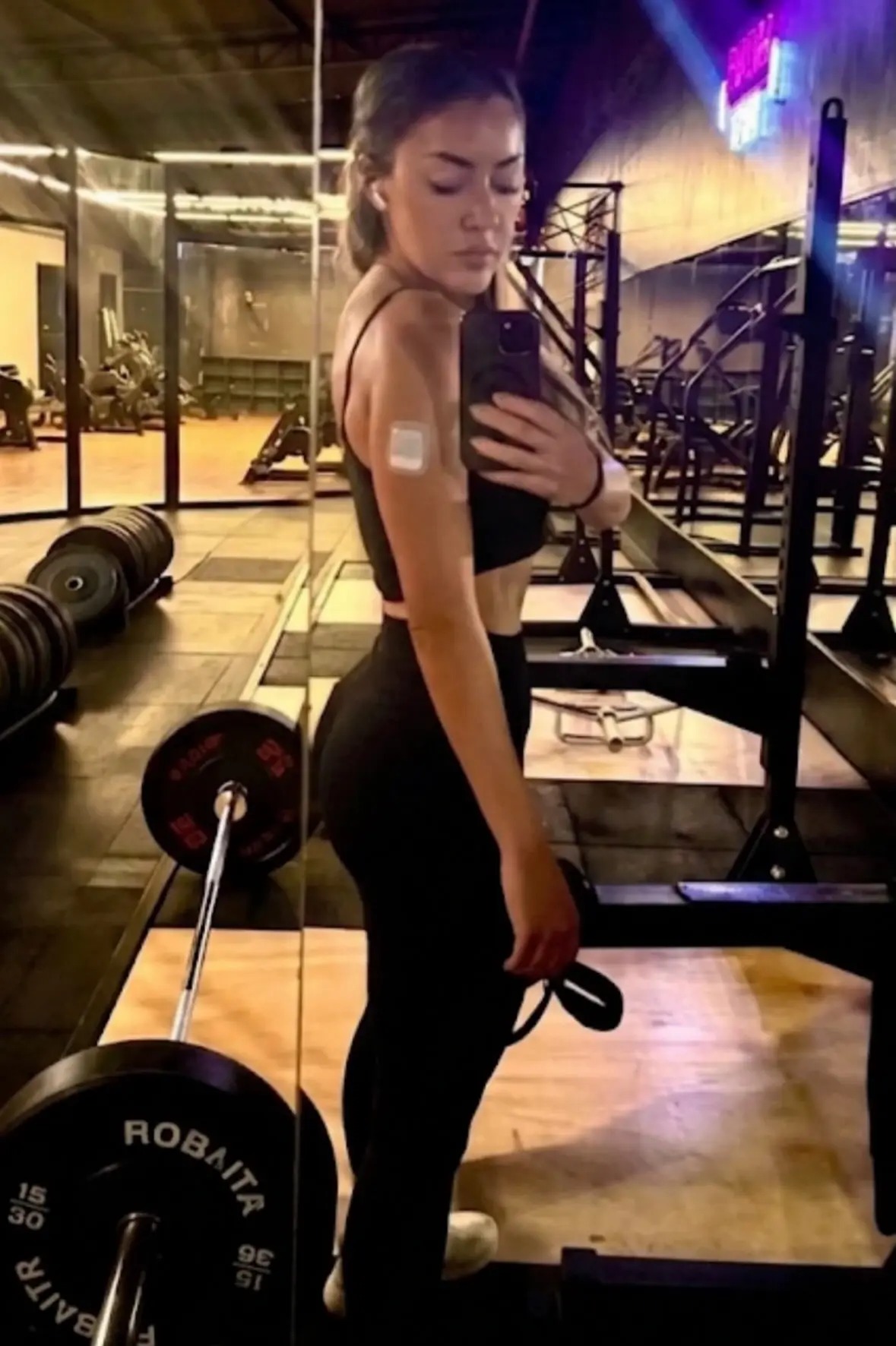 Paula wearing a Medtrum Nano patch pump on her arm while taking a gym selfie.